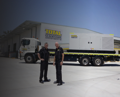 Total Generators' team of two stand in front of the head office and generator truck